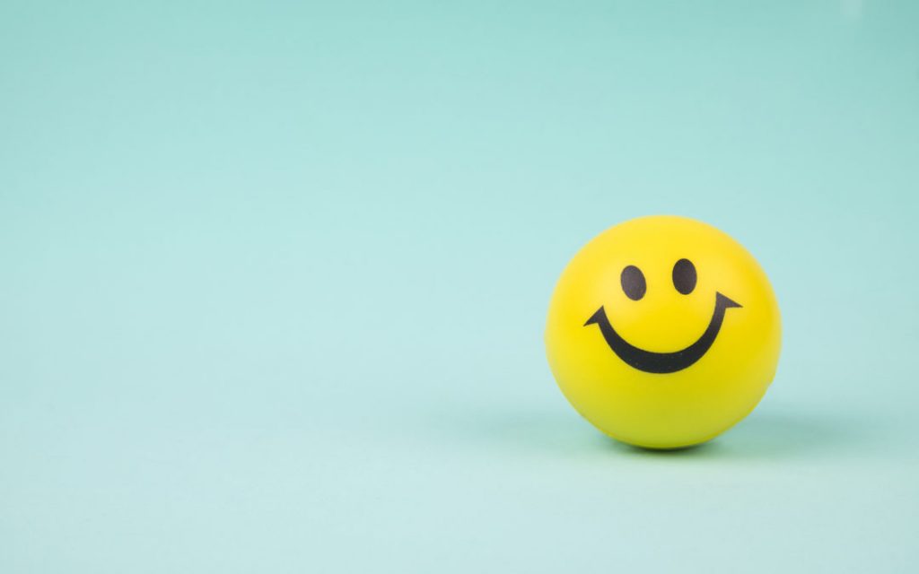 Yellow laughing happy smile face. Smiley face ball on background sweet retro vintage color.